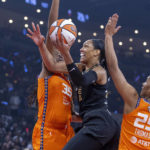 
              Las Vegas Aces forward A'ja Wilson, center, gets inside of Connecticut Sun forwards Jonquel Jones (35) and Alyssa Thomas (25) for a shot during the first half in Game 1 of a WNBA basketball final playoff series Sunday, Sept. 11, 2022, in Las Vegas. (AP Photo/L.E. Baskow)
            