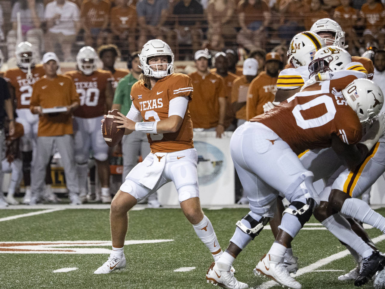 Texas quarterback Quinn Ewers, front left, looks to pass during the first half of an NCAA college f...