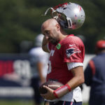 
              New England Patriots quarterback Brian Hoyer removes his helmet during an NFL football practice, Wednesday, Aug. 31, 2022, in Foxborough, Mass. (AP Photo/Steven Senne)
            