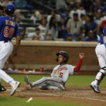 
              Washington Nationals' CJ Abrams (5) scores a run against the New York Mets during the ninth inning of a baseball game Saturday, Sept. 3, 2022, in New York. (AP Photo/Noah K. Murray)
            