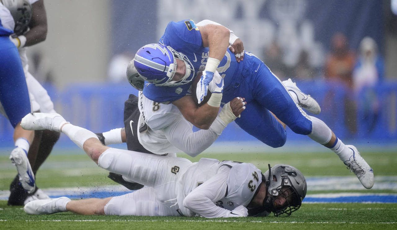 Air Force running back Brad Roberts, top right, is stopped after a short gain by Colorado linebacke...