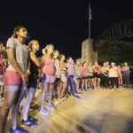 
              Members of the Tupelo Running Club and others gather for a moment of silence before they begin their "Liza's Lights" run early Friday morning, Spet. 9, 2022, in Tupelo Miss., to remember Eliza Fletcher, who was abducted and murdered while she was running in the early morning hours in Memphis, Tenn. (Thomas Wells/The Northeast Mississippi Daily Journal via AP)
            