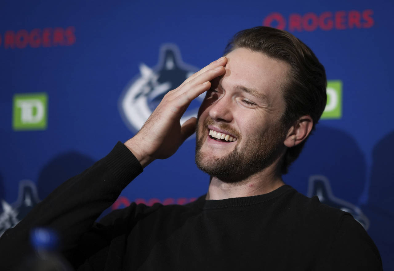 ancouver Canucks goalie Thatcher Demko laughs while responding to questions during a news conferenc...