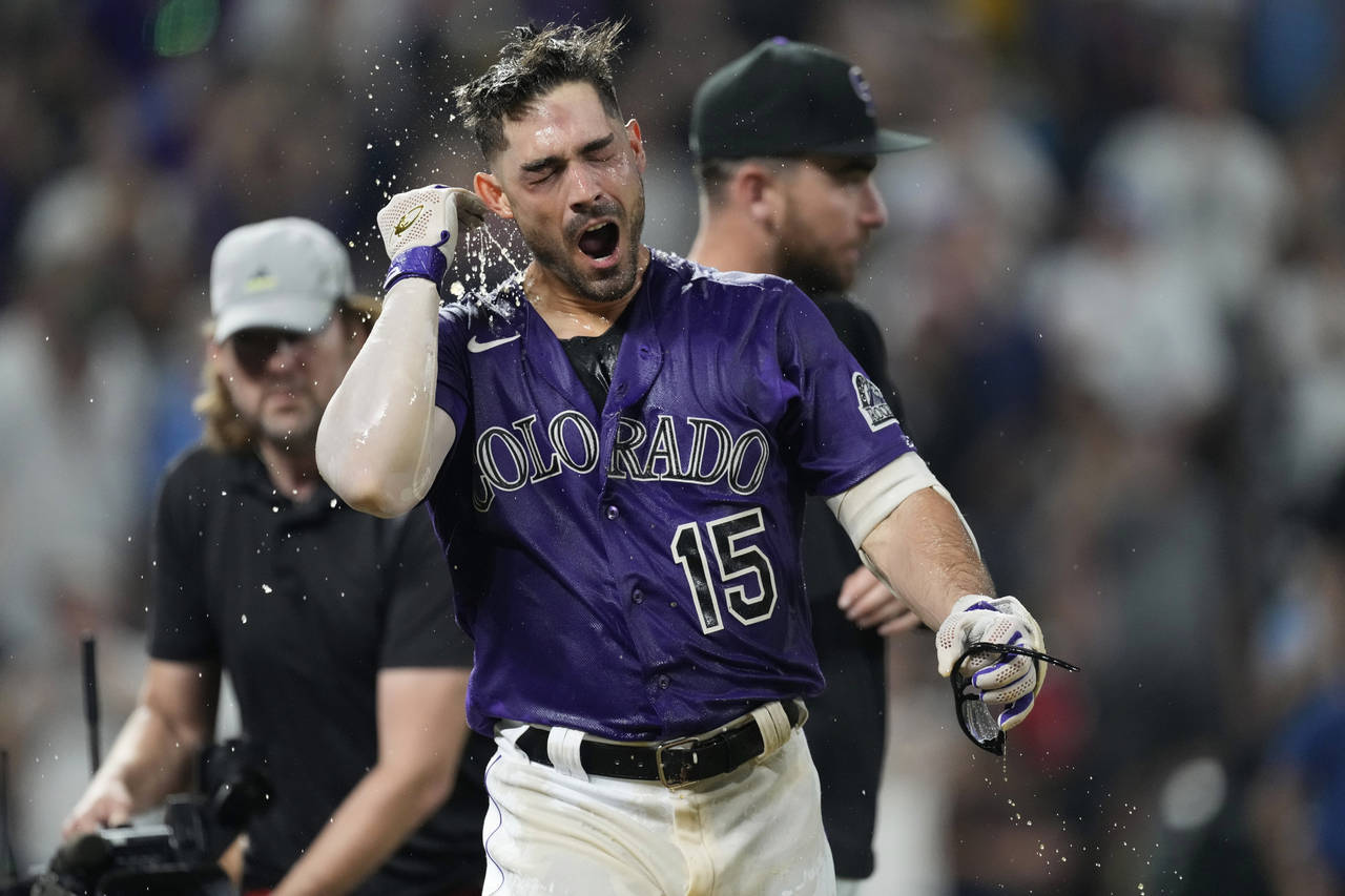 Colorado Rockies' Randal Grichuk reacts to having been doused by teammates after crossing home plat...