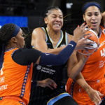 
              Chicago Sky forward Candace Parker, center, drives to the basket against Connecticut Sun guard Odyssey Sims, left, and center Brionna Jones during the second half of Game 2 in a WNBA basketball playoffs semifinal Wednesday, Aug. 31, 2022, in Chicago. The Sky won 85-77. (AP Photo/Nam Y. Huh)
            