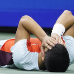 
              Carlos Alcaraz, of Spain, lays on the court after defeating Frances Tiafoe, of the United States, during the semifinals of the U.S. Open tennis championships, Friday, Sept. 9, 2022, in New York. (AP Photo/John Minchillo)
            