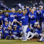
              Los Angeles Dodgers manager Dave Roberts, front, cheers with the team in the background after the Dodgers' baseball game against the Arizona Diamondbacks in Phoenix, Tuesday, Sept. 13, 2022. The Dodgers won 4-0 and clinched the National League West. (AP Photo/Ross D. Franklin)
            