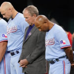 
              Former President George W. Bush, second from front right, stands with Texas Rangers interim manager Tony Beasley, front right, and others for a moment of silence for 9/11 before a baseball game between the Toronto Blue Jays and the Rangers in Arlington, Texas, Sunday, Sept. 11, 2022. (AP Photo/LM Otero)
            
