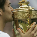 
              FILE - Roger Federer of Switzerland, kisses the winners' trophy after defeating Andy Roddick 6-2, 7-6 (2), 6-4 in the Mens' Singles Final on Centre Court at Wimbledon Sunday, July 3, 2005. Federer announced Thursday, Sept.15, 2022 he is retiring from tennis. (AP Photo/Alastair Grant, File)
            