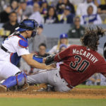 
              Arizona Diamondbacks' Jake McCarthy, right, scores under the tag of Los Angeles Dodgers catcher Austin Barnes on a sacrifice fly by Emmanuel Rivera during the seventh inning of a baseball game Wednesday, Sept. 21, 2022, in Los Angeles. (AP Photo/Mark J. Terrill)
            