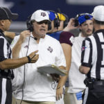 
              Texas A&M coach Jimbo Fisher confers with head line judge Chad Green, left, and referee Ken Williamson during the second half of the team's NCAA college football game against Arkansas on Saturday, Sept. 24, 2022, in Arlington, Texas. Texas A&M won 23-21. (AP Photo/Brandon Wade)
            