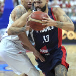 
              Evan Fournier of France, right, is challenged by Poland's A.J. Slaughter, left, during the Eurobasket semi final basketball match between Poland and France in Berlin, Germany, Friday, Sept. 16, 2022. (AP Photo/Michael Sohn)
            