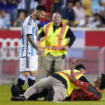 
              A fan is tackled as he tries to take a picture of Argentina's player Lionel Messi during the second half of an international friendly soccer match against Jamaica on Tuesday, Sept. 27, 2022, in Harrison, N.J. (AP Photo/Eduardo Munoz Alvarez)
            