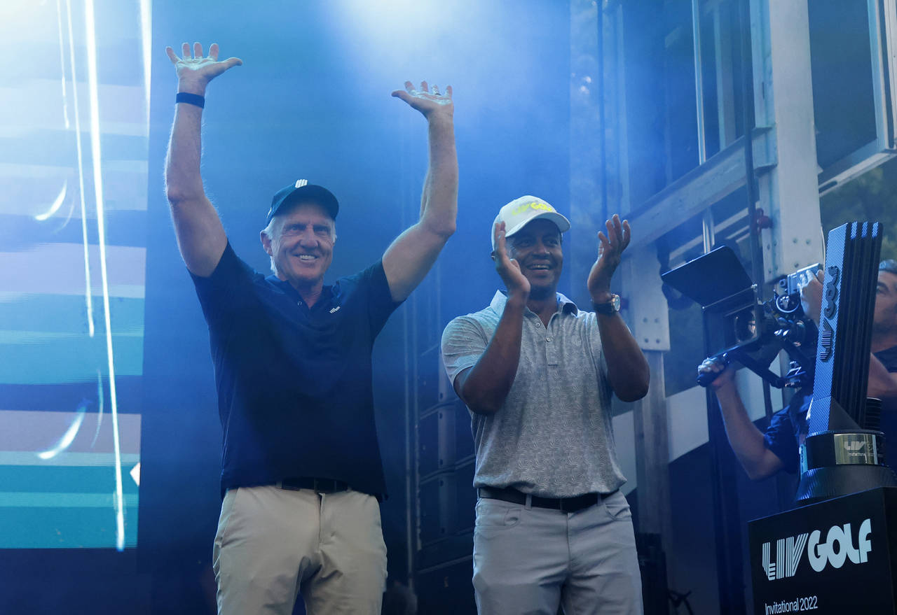 LIV Golf CEO Greg Norman, left, and LIV Golf managing director Majed Al Sorour cheer from the stage...