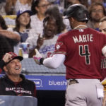 
              Arizona Diamondbacks' Ketel Marte, center, is congratulated by manager Torey Lovullo after hitting a solo home run during the seventh inning of a baseball game against the Los Angeles Dodgers Tuesday, Sept. 20, 2022, in Los Angeles. (AP Photo/Mark J. Terrill)
            
