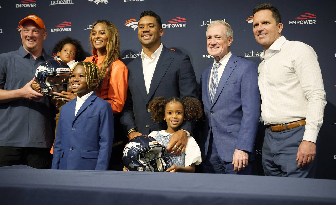 Denver Broncos quarterback Russell Wilson, center, is joined by team officials, his family and agen...