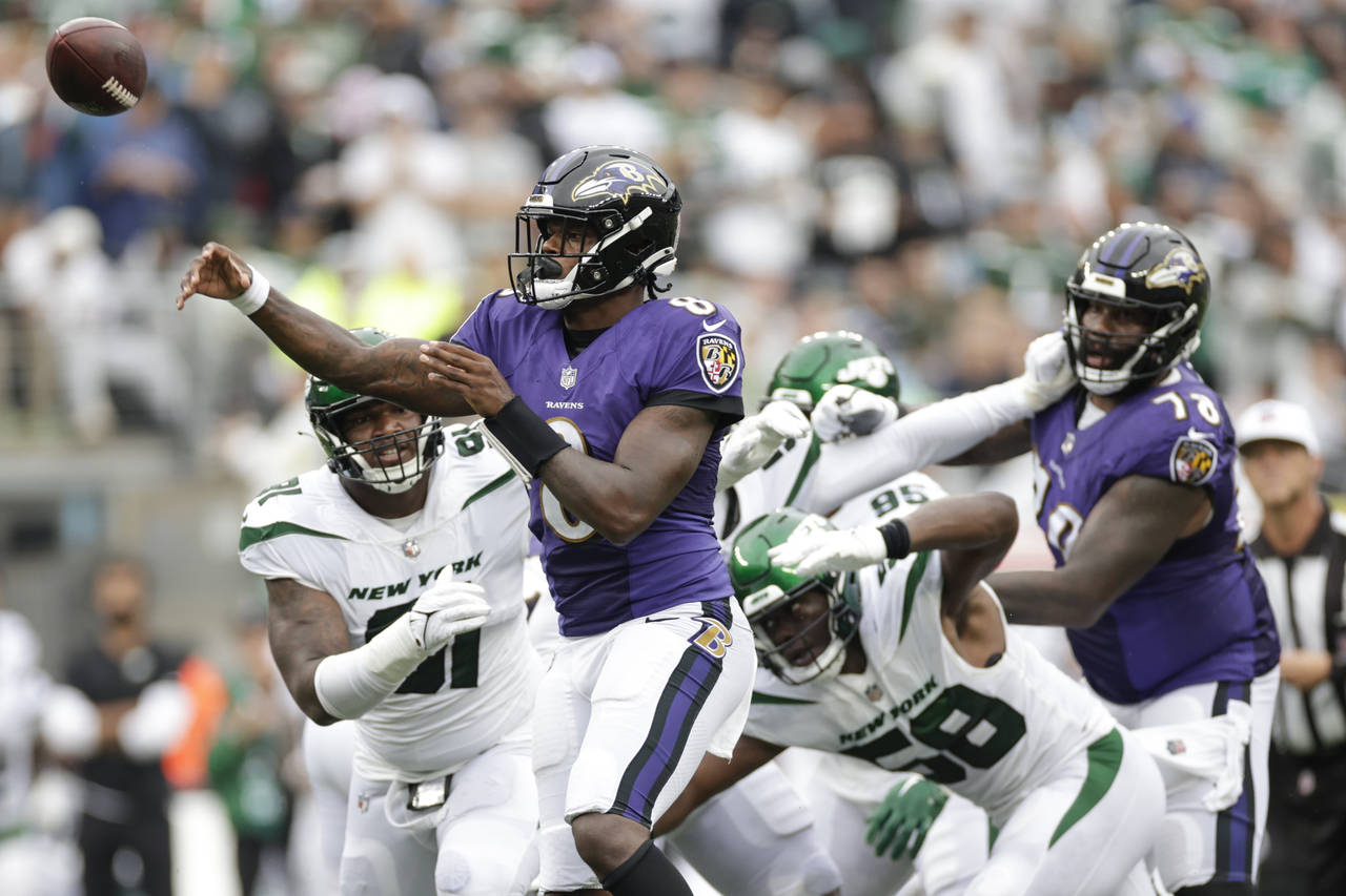 Baltimore Ravens' Lamar Jackson (8) throws a pass to Devin Duvernay for a touchdown during the seco...