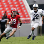 
              Georgia quarterback Stetson Bennett (13) eludes Samford linebacker Brayden DeVault-Smith (22) as he looks for an open receiver during the first half of an NCAA college football game, Saturday, Sept. 10, 2022 in Athens, Ga. (AP Photo/John Bazemore)
            