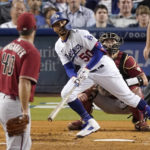 
              Los Angeles Dodgers' Mookie Betts, center, heads to first as he hits a solo home run as Arizona Diamondbacks starting pitcher Madison Bumgarner, left, and catcher Carson Kelly watch during the fourth inning of a baseball game Wednesday, Sept. 21, 2022, in Los Angeles. (AP Photo/Mark J. Terrill)
            
