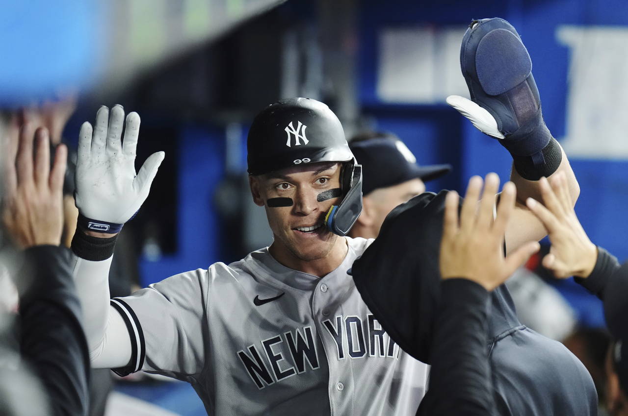 New York Yankees' Aaron Judge is congratulated after scoring a run against the Toronto Blue Jays du...