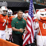 
              Miami head coach Mario Cristobal, center, prepares to run onto the field before an NCAA college football game against Bethune Cookman, Saturday, Sept. 3, 2022, in Miami Gardens, Fla. (AP Photo/Lynne Sladky)
            