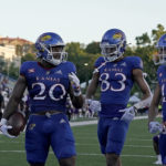 
              Kansas running back Daniel Hishaw Jr. (20) celebrates with wide receivers Quentin Skinner (83) and Luke Grimm (11) after scoring a touchdown during the first half of an NCAA college football game against Tennessee Tech Friday, Sept. 2, 2022, in Lawrence, Kan. (AP Photo/Charlie Riedel)
            
