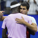 
              Carlos Alcaraz, of Spain, right, hangs Frances Tiafoe, of the United States, after winning their semifinal match of the U.S. Open tennis championships, Friday, Sept. 9, 2022, in New York. (AP Photo/John Minchillo)
            