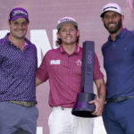 
              Cameron Smith winner of the LIV Golf Invitational-Chicago tournament stands with third place finisher Peter Uihlein, left, and second place finisher Dustin Johnson after the tournament Sunday, Sept. 18, 2022, in Sugar Hill, Ill. (AP Photo/Charles Rex Arbogast)
            