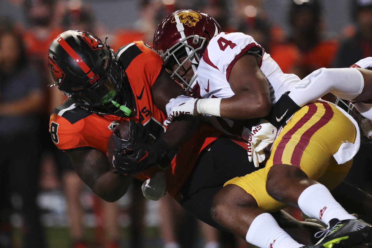 Oregon State running back Jam Griffin is brought down by Southern California defensive back Max Wil...