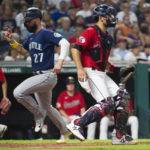 
              Seattle Mariners' Jesse Winker (27) scores on an RBI-single by Cal Raleigh as Cleveland Guardians' Luke Maile, right, looks on during the fifth inning of a baseball game in Cleveland, Saturday, Sept. 3, 2022. (AP Photo/Phil Long)
            
