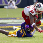 
              North Carolina State's Devin Carter (88) stretches for extra yards in the grasp of East Carolina's Damel Hickman (23) during the first half of an NCAA college football game in Greenville, N.C., Saturday, Sept. 3, 2022. (AP Photo/Karl B DeBlaker)
            