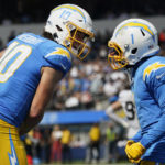 
              Los Angeles Chargers quarterback Justin Herbert (10) celebrates with wide receiver DeAndre Carter during the first half of an NFL football game against the Las Vegas Raiders in Inglewood, Calif., Sunday, Sept. 11, 2022. (AP Photo/Marcio Jose Sanchez)
            