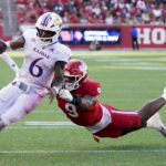 
              Kansas quarterback Jalon Daniels (6) escapes a tackle by Houston defensive lineman Nelson Ceaser en route to a touchdown during the second half of an NCAA college football game, Saturday, Sept. 17, 2022, in Houston. (AP Photo/Eric Christian Smith)
            