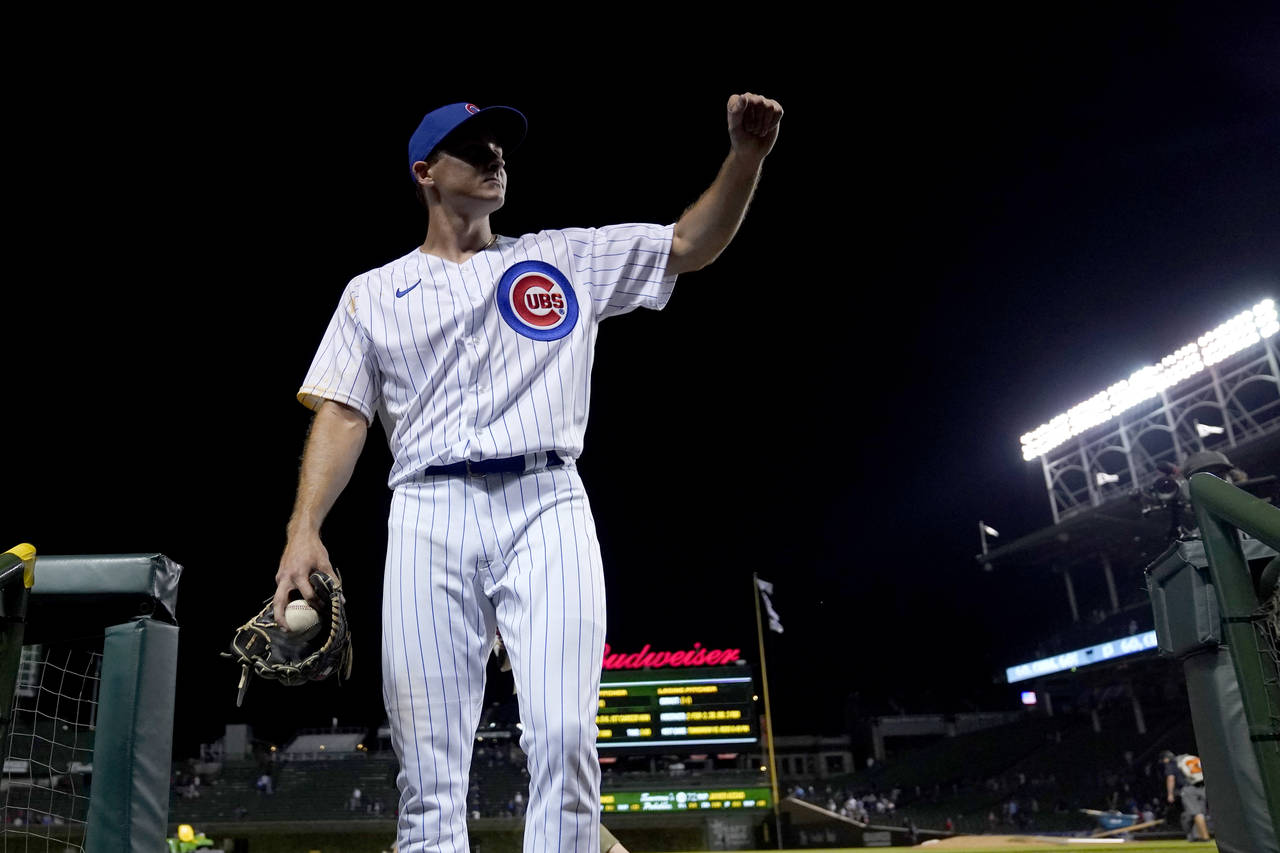 Chicago Cubs relief pitcher Hayden Wesneski gestures to the crowd as he leaves the field with the g...