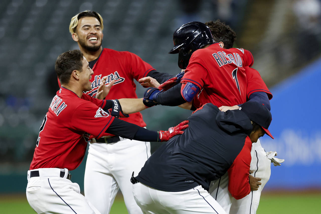 Cleveland Guardians' Amed Rosario (1) celebrates with teammates after hitting a game-winning single...