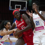 
              Canada's Laeticia Amihere runs between Puerto Rico's Jennifer O'Neill, left, and Mya Hollingshed during their quarterfinal game at the women's Basketball World Cup in Sydney, Australia, Thursday, Sept. 29, 2022. (AP Photo/Mark Baker)
            