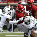 
              Louisville running back Trevion Cooley (23) is tackled by South Florida defensive back Aamaris Brown (9), and defensive back Mekhi LaPointe (22) during the second half of an NCAA college football game in Louisville, Ky., Saturday, Sept. 24, 2022. Louisville won 41-3. (AP Photo/Timothy D. Easley)
            