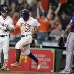 
              Houston Astros' Jose Altuve (27) scores the winning run on a wild pitch by Texas Rangers relief pitcher Jonathan Hernandez (72) during the 10th inning of a baseball game Wednesday, Sept. 7, 2022, in Houston. (AP Photo/Eric Christian Smith)
            