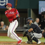 
              Texas Rangers' Kevin Plawecki, left, swings through after hitting a single in front of Cleveland Guardians catcher Luke Maile, center, and umpire Pat Hoberg, right, during the second inning of a baseball game in Arlington, Texas, Friday, Sept. 23, 2022. Rangers' Adolis Garcia scored from second on the play. (AP Photo/LM Otero)
            