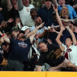 
              Fans reach for a ball hit for a two-run home run by Atlanta Braves' Vaughn Grissom in the fourth inning of a baseball game against the Miami Marlins, Friday, Sept. 2, 2022, in Atlanta. (AP Photo/John Bazemore)
            