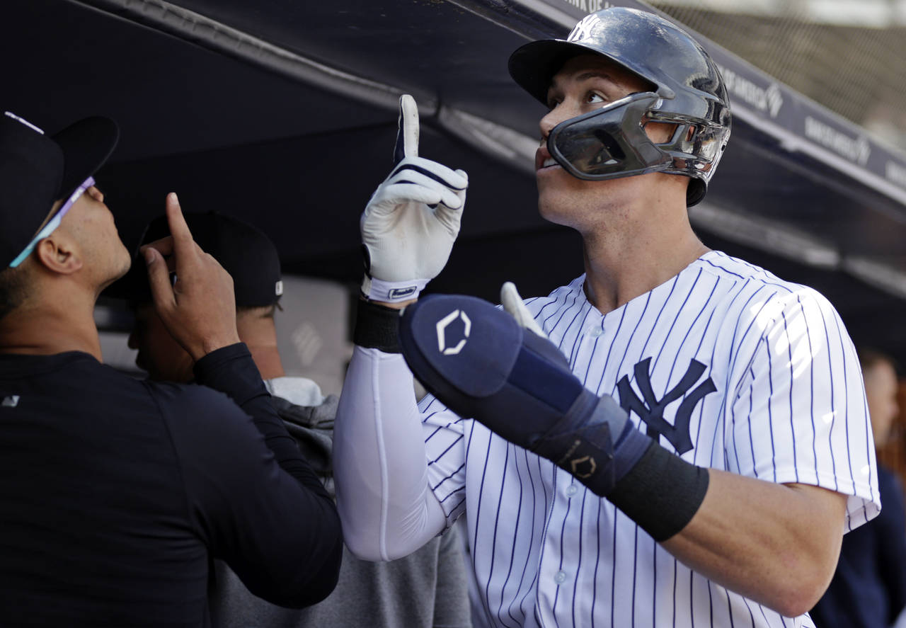 New York Yankees' Aaron Judge reacts in the dugout after scoring a run during the first inning of t...