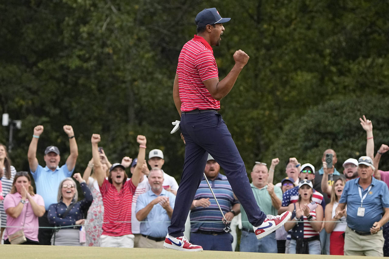 Tony Finau celebrates his victory over Sebastian Munoz, of Colombia, on the 17th green during their...