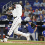 
              Miami Marlins' Charles Leblanc hits a single next to Chicago Cubs catcher P.J. Higgins during the first inning of a baseball game Tuesday, Sept. 20, 2022, in Miami. (AP Photo/Lynne Sladky)
            