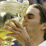 
              FILE - Roger Federer kisses the winner's trophy after winning the Men's Singles final on the Centre Court at Wimbledon, Sunday July 4, 2004. Federer won the match 4-6, 7-5, 7-6 (3), 6-4, to retain the title. Federer announced Thursday, Sept.15, 2022 he is retiring from tennis.(AP Photo/Anja Niedringhaus, File)
            