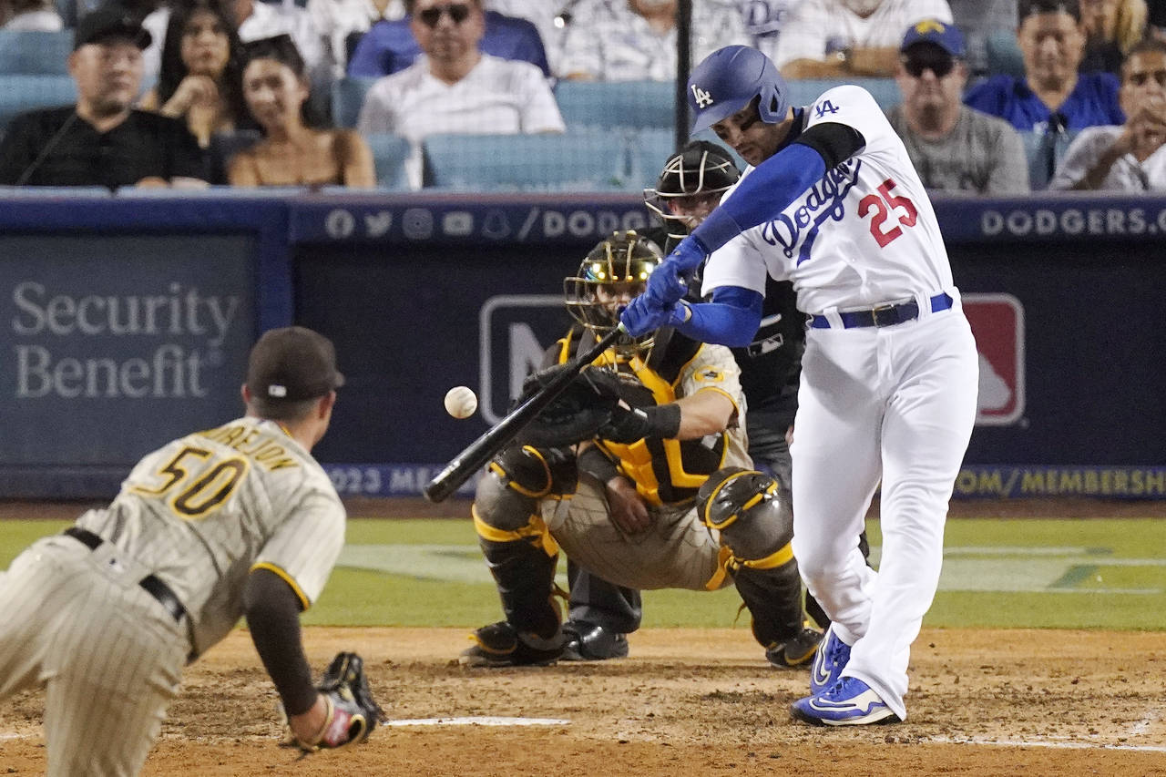 Los Angeles Dodgers' Trayce Thompson, right, hits a three-run home run as San Diego Padres relief p...