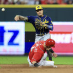 
              Milwaukee Brewers' Kolten Wong, top, forces out Cincinnati Reds' Matt Reynolds, bottom, as he throws to first base to turn a double play during the sixth inning of a baseball game in Cincinnati, Friday, Sept. 23, 2022. (AP Photo/Aaron Doster)
            