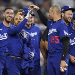 
              Los Angeles Dodgers' Mookie Betts, center, is greeted by Trayce Thompson (25) and other teammates after he hit a walk-off single to win a baseball game 3-2 against the Arizona Diamondbacks in Los Angeles, Thursday, Sept. 22, 2022. Freddie Freeman scored. (AP Photo/Ashley Landis)
            