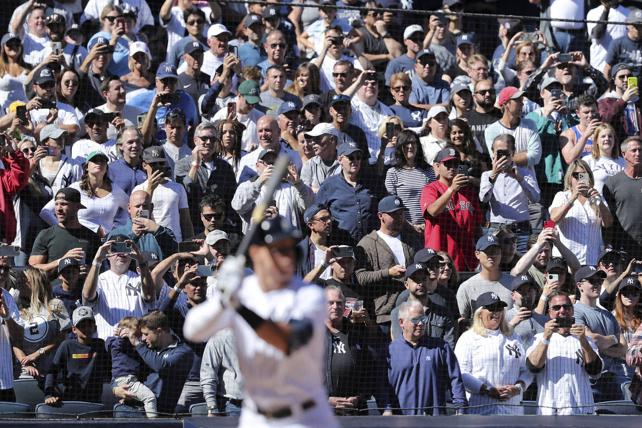 Fans cheer as New York Yankees' Aaron Judge prepares to bat against the Boston Red Sox during the t...