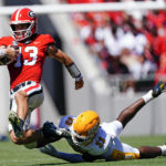 
              Georgia quarterback Stetson Bennett (13) is tripped up by Kent State linebacker Marvin Pierre (33) in the first half of an NCAA college football game Saturday, Sept. 24, 2022, in Athens, Ga. (AP Photo/John Bazemore)
            