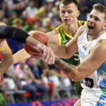 
              Slovenia's Luka Doncic, right, and Lithuania's Marius Grigonis, left, fight for the ball during the Eurobasket group B basketball match Slovenia against Lithuania, in Cologne, Germany, Thursday, Sept. 1, 2022. (Federico Gambarini/dpa via AP)
            